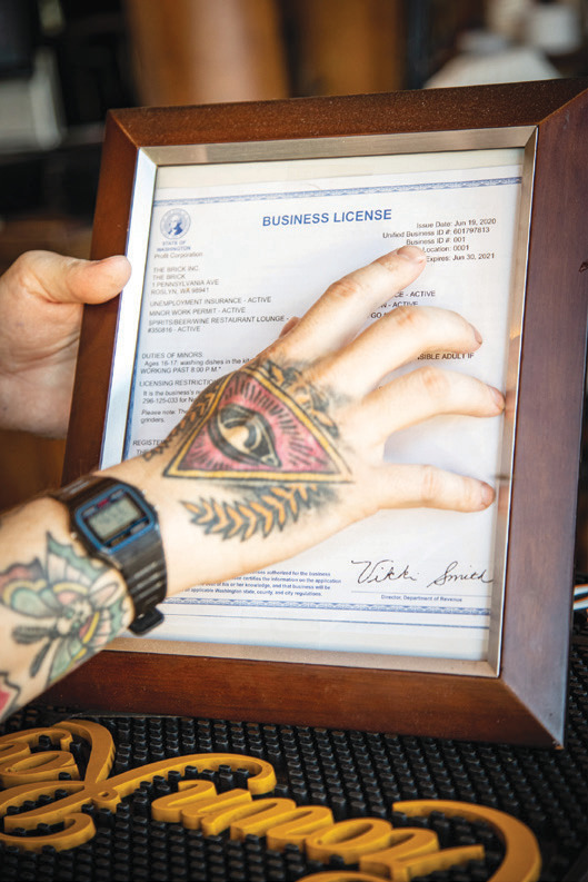 The bartender pulls the business license off the wall, pointing to its issuance number: 1.