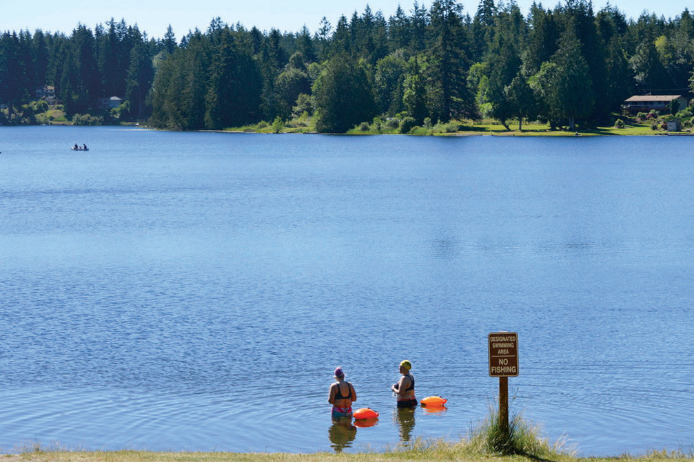 Open water swimmers at Wildcat Lake near Seabeck tow light buoys to be easily seen.