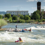 Kayakers play on Brennan’s Wave, a manmade playground on the Clark Fork River in Missoula.