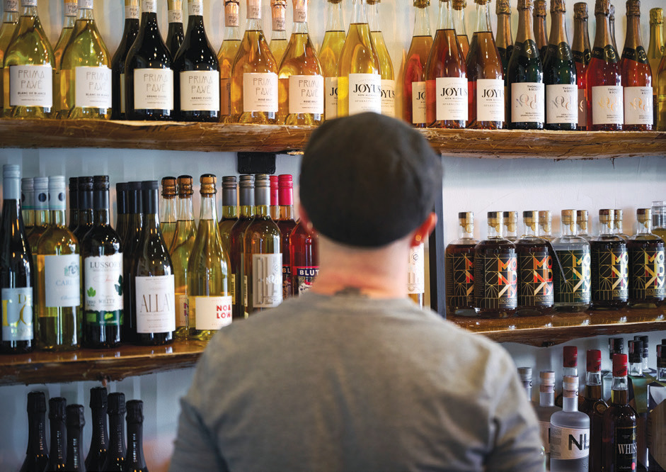 A shopper peruses shelves of nonalcoholic options at Cheeky & Dry.